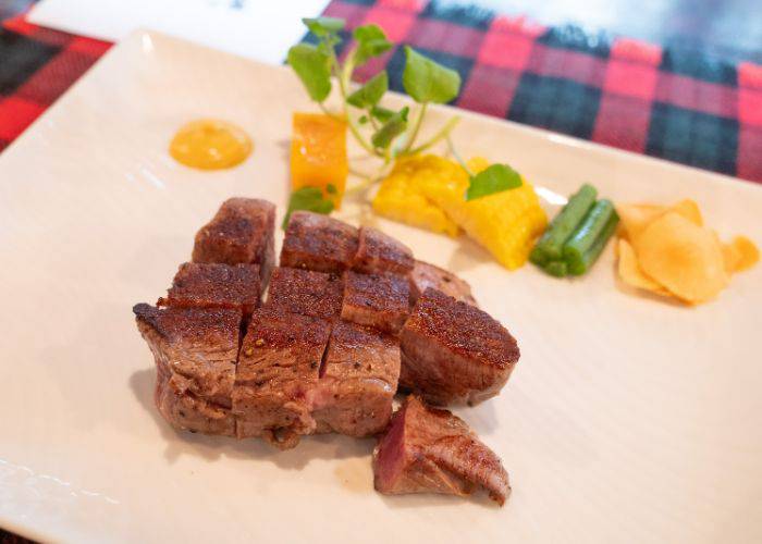 Carefully sliced chunks of premium wagyu beef at  Kuishinbo Yamanaka, served with pickled vegetables and sauce.